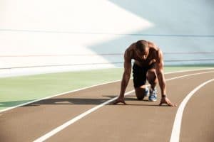 jeune-homme-sport-afro-americain-position-depart-pret-commencer-piste-sport-au-stade